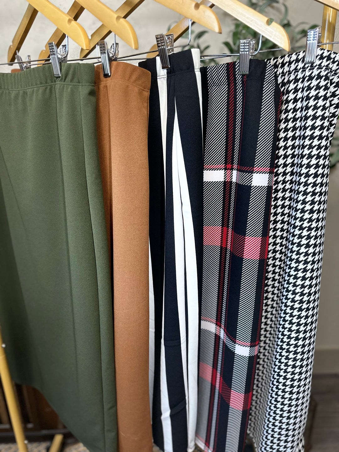 Juliette Pull-On Midi Skirt in olive, maple brown, striped, plaid and houndstooth, all five colors on a rack