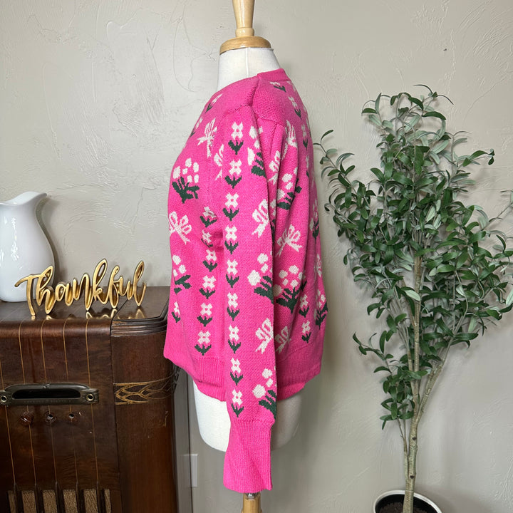 Rosie Bow and Flower Pullover Sweater in pink, long sleeve with ribbed cuff, side view