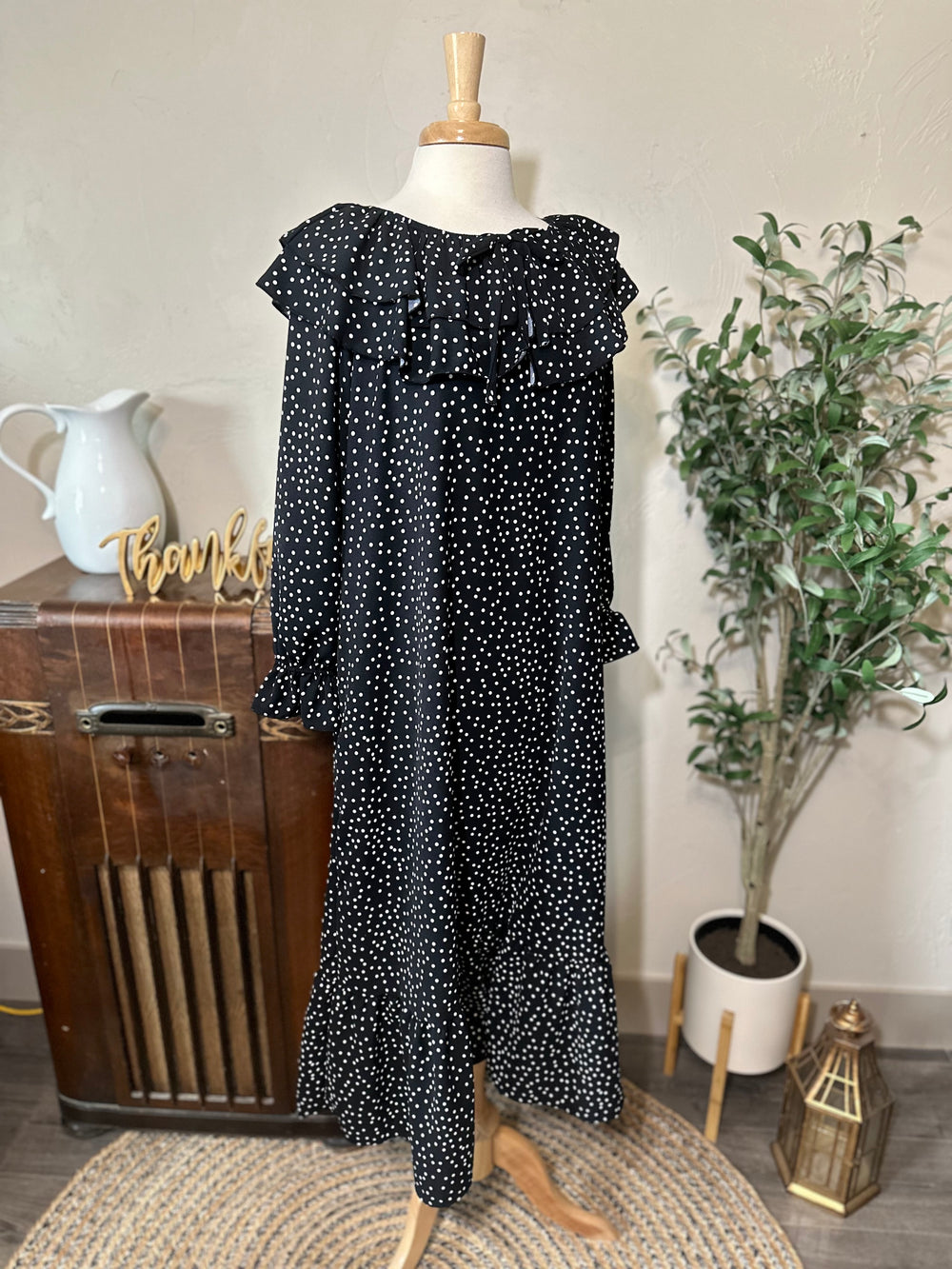 Front view of the black and white polka dot dress showing the ruffle collar and ruffled cuffs