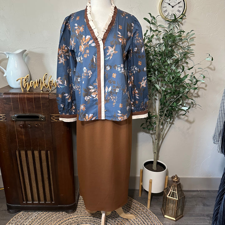 Full front view of the floral blouse styled with a brown midi skirt