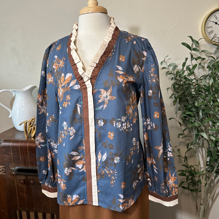 Angled front view of the ruffle V-neckline and long full sleeves